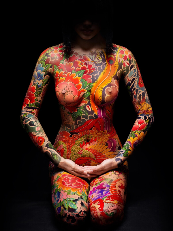 Miss Kō - Photographie d'une femme tatouée assise de face